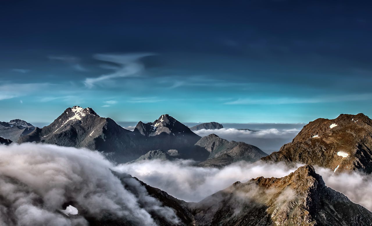 A stunning view of snow-capped mountains in the Lofoten Archipelago surrounded by clouds.